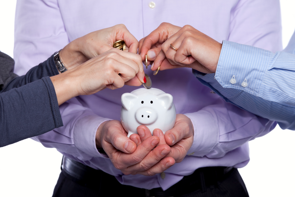 business people saving money in piggy bank