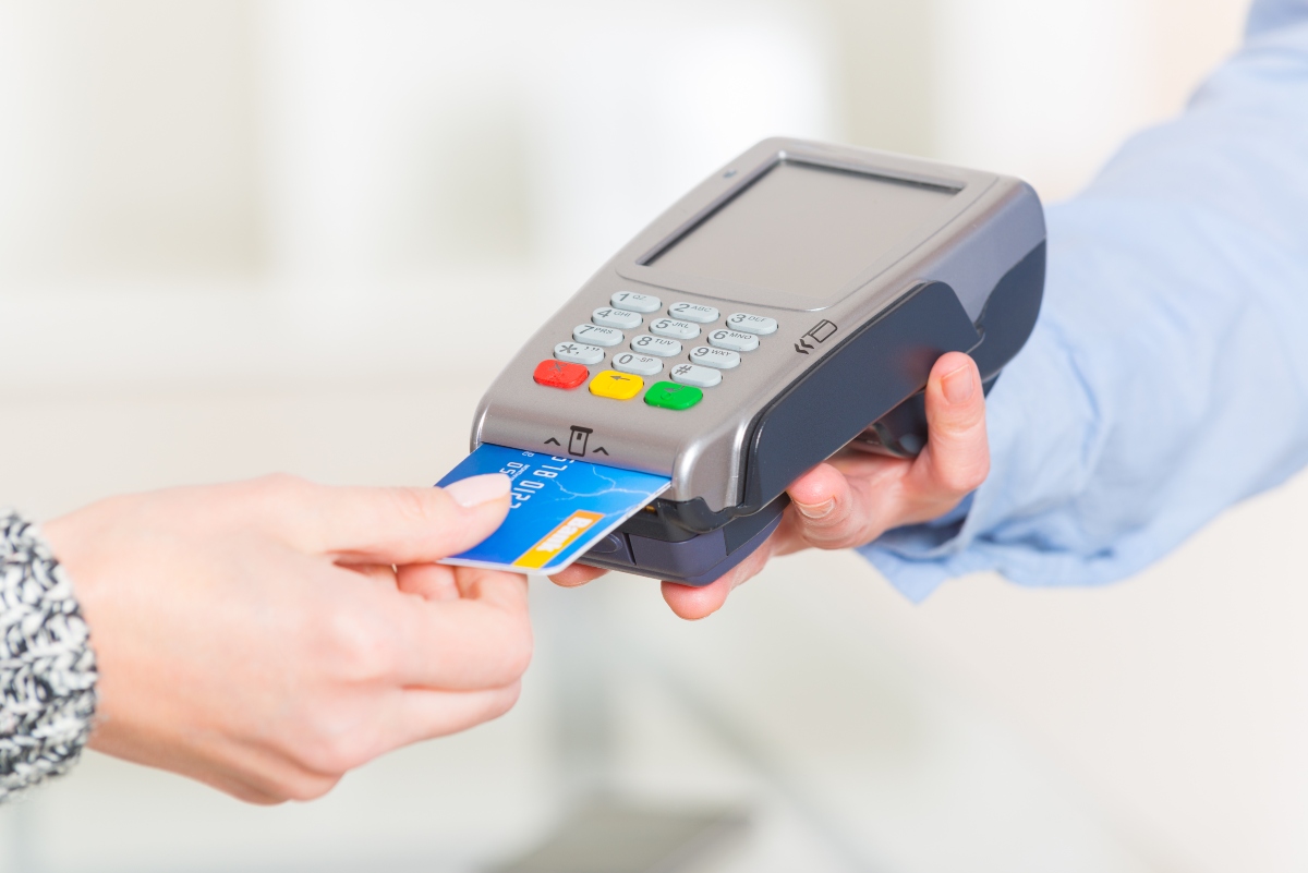 Paying with credit or debit card in wireless payment terminal at shop