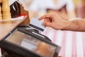 Close-up image of cashier male hands holding card