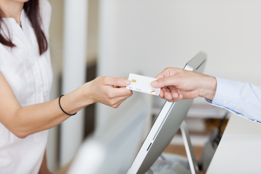 man handing payment card to business woman